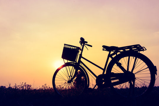 beautiful landscape image with silhouette Bicycle at sunset