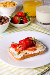 breakfast: Fresh toast with strawberry, banana and nuts, cornflakes, orange juice, milk