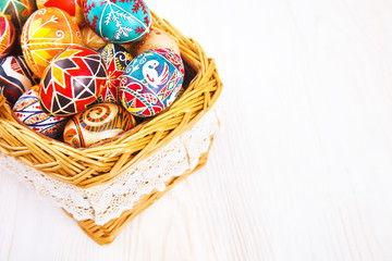 Fototapeta na wymiar Easter eggs in a basket on white table.