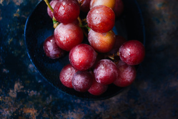 Bunch of grapes on black plate. Top view.