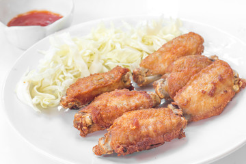 Chicken wings in plate with tomato sauce.