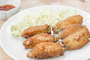 Chicken wings in plate with tomato sauce.