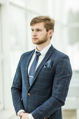 newcomer businessman in a business suit stands near the window