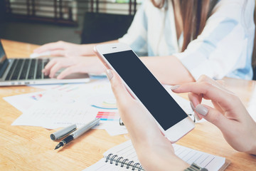 woman hand working with phone on wooden desk in office. can be used on advertising