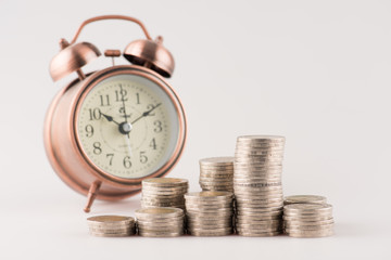 Close up of stacking gold coins with alarm clock ,Business Finance and Money concept,Save money for prepare in the future.