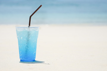 Blue hawaii soda tropical drink on clear sky over sea beach. Summer holiday relax background with copy space.