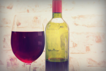 Bottle of red wine with glass ready to pour