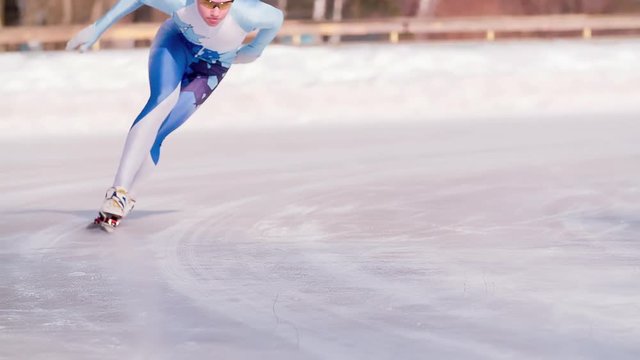 Speed ice skater skating on outdoor race on turn HD slow-motion video. Professional athlete training for winter olympic. View of legs on skates