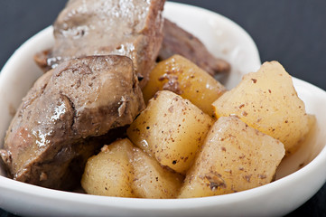 Stewed chicken liver with apples on a white plate, food, diet food.