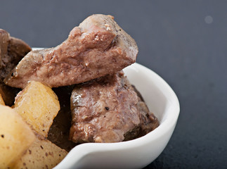Stewed chicken liver with apples on a white plate, food, diet food.