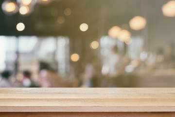 Brown wood table floor scene of blurred bokeh cafe restaurant light. Background with copy space for display product business decorate design.