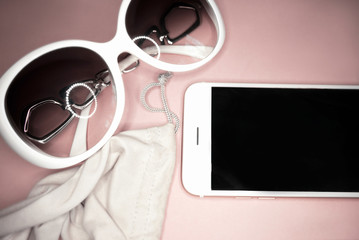 white frame sunglasses and white smartphone