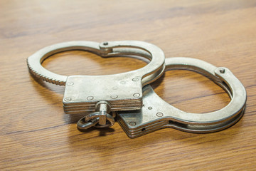 handcuff or shackle on wooden background