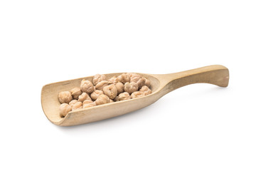 Wooden spoon with chick peas and handle pointing to the right on a white background