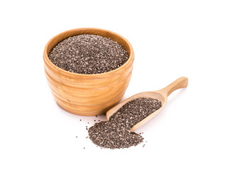 Wooden bowl with chia seeds and a spoon to the right of it on white background