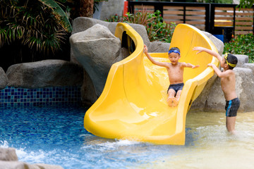 Young boy play water slide