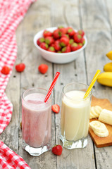 Strawberry and banana milkshake smoothie in the glass with straw