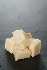 pieces of hard parmesan cheese on slate board, closeup photo