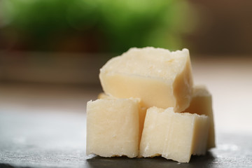 pieces of hard parmesan cheese on slate board, closeup photo