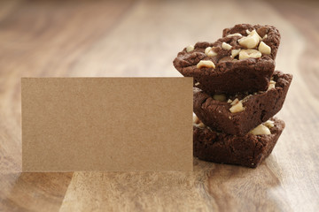 homemade heart shaped chocolate cookies paper card on wood table, shallow focus