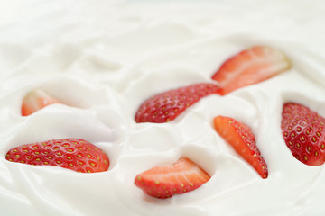 macro photo of organic yogurt with fresh sliced strawberries, food background