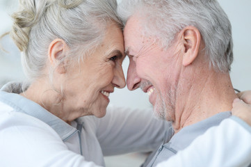 Happy elderly couple standing embracing