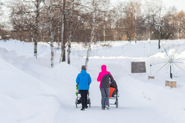 Mother walking with a stroller in the winter