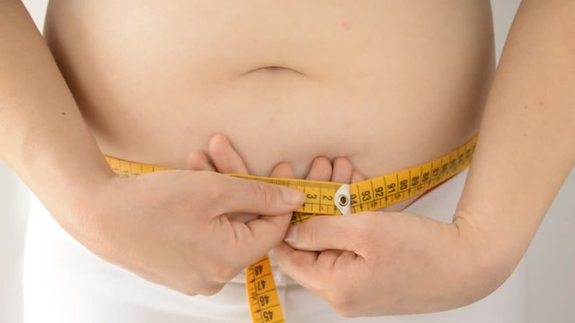 woman measuring his waist