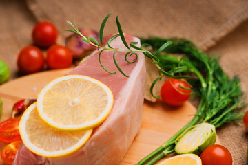 Raw pork on cutting board and vegetables 