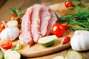 Slices of raw pork meat and vegetables 