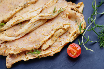 Raw marinated pork meat and sliced tomato