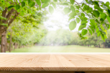 Empty wooden table with garden bokeh for a catering or food background with a country outdoor theme,Template mock up for display of product