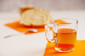 Tea cup and slice of sweet cream roll