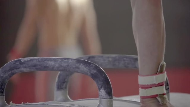 Gymnast doing routine exercises on pommel horse HD video. Close-up of athlete hand on gymnastics apparatus.