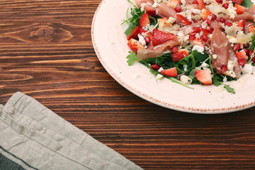 Arugula salad with strawberries, feta cheese, prosciutto, parmes
