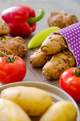 Pepper, potato, kaiser bun and baguette on wood table. Vegetarian bio food concept.