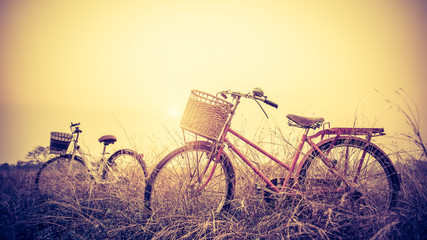 beautiful landscape image with two bicycle at sunset ; vintage filter style