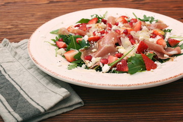 Arugula salad with strawberries, feta cheese, prosciutto, parmes