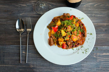 Chili, stew, ragout: beef, potatoes, red bean, pepper, chili pepper, carrot, tomatoes, spices, fennel, sauce chili cooked and served on a white plate.