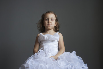 Little girl in a smart white dress. Human emotions. Joke, tomfoolery