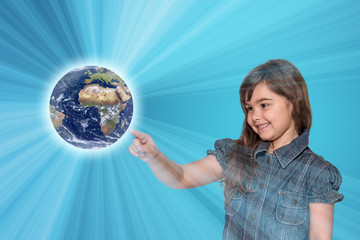 Smiling little girl is touching the Planet Earth All is on on the blue gradient background with light rays.  Elements of this image furnished by NASA.
