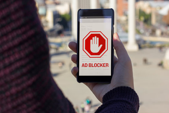 Young man using mobile and ad blocker message ion the screen