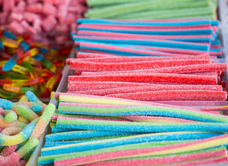 Mixed colorful bonbon close up. Background with various colorful candy. Long chewy jelly sweet candies.