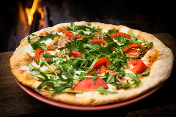 Pizza vegetariana con carciofi, rucola, pomodoro e mozzarella