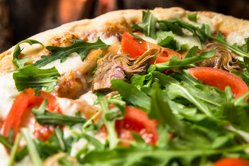Pizza vegetariana con carciofi, rucola, pomodoro e mozzarella