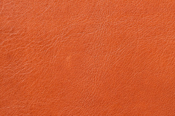 Fototapeta premium Texture of genuine leather close-up, cowhide, orange. For natural, artisan backgrounds, backdrop, substrate composition use