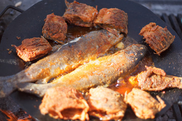 Trout fish frying in pan on the fire
