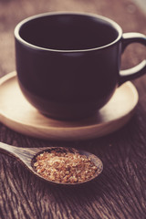 Fototapeta na wymiar Raw Organic Cane Sugar in a wooden spoon with coffee cup