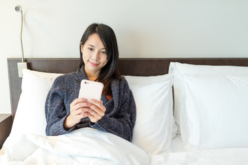 Woman use of cellphone and lay down on bed