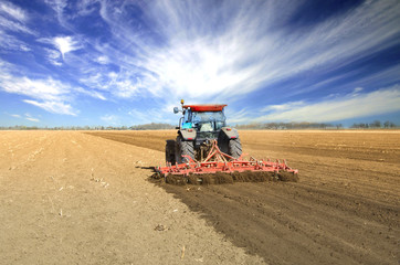 Agriculture. Farmer in tractor preparing the land for next season. Field work. Agronomy concept.